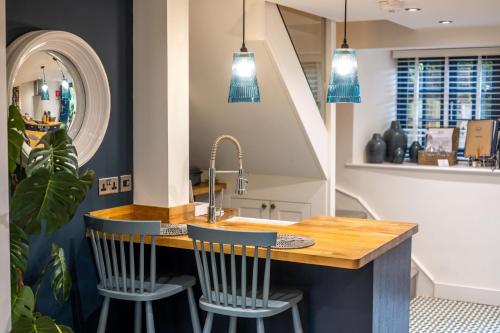 a kitchen with a sink and a counter with two chairs at No 33 Cottage 2 in Thornham