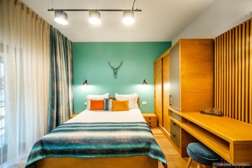 a bedroom with a bed and a desk in a room at Anais Chalet in Câmpulung Moldovenesc