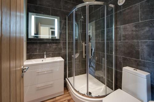 a bathroom with a shower and a toilet and a sink at Smiddy in Melrose