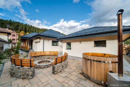 a patio with benches and a fire pit in front of a house at Anais Chalet in Câmpulung Moldovenesc