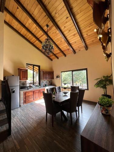 a kitchen and dining room with a table and chairs at Cabaña No.2 Puerta del Bosque Mazamitla. in Mazamitla