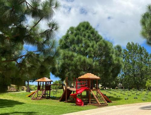 a playground with two play equipment in a park at Cabaña No.2 Puerta del Bosque Mazamitla. in Mazamitla