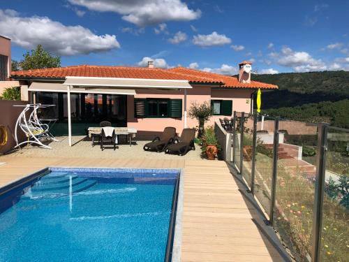 a villa with a swimming pool in front of a house at Quinta da Penada - Vineyard & Winery - Suíte 3 in Chaves