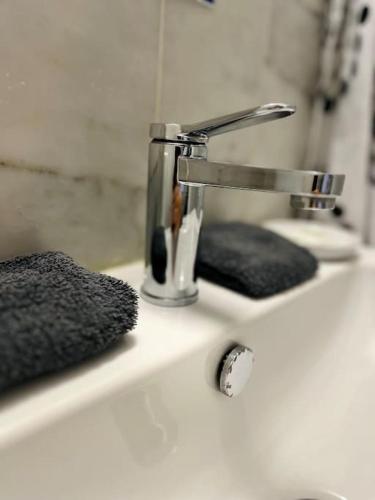 - un lavabo avec un porte-brosse à dents et un robinet dans l'établissement ''Ophélia 84'' Duplex en centre ville avec parking, à Sète