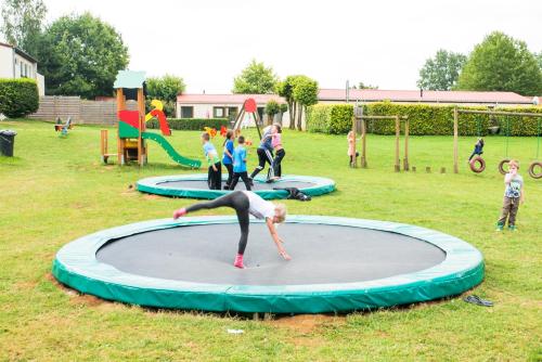 grupa dzieci bawiących się na trampolinie w obiekcie Camping la Colline w mieście Virton