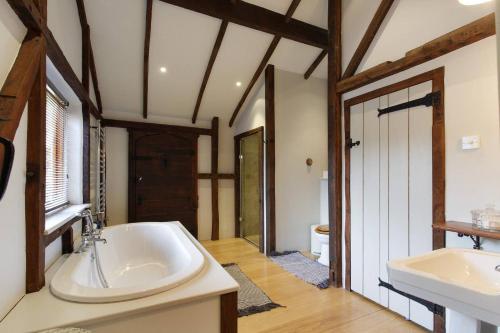 uma grande casa de banho com 2 lavatórios e uma banheira em Barn conversion, Henley-on-Thames em Henley on Thames