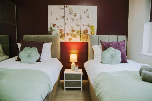 dos camas sentadas una al lado de la otra en una habitación en Lovely Three Bed at Tanglewood en Hillingdon