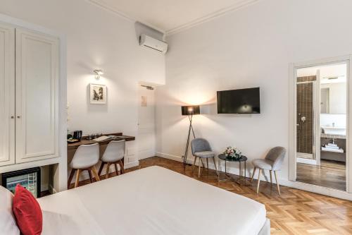 a bedroom with a bed and a desk and chairs at Little Queen Relais in Rome