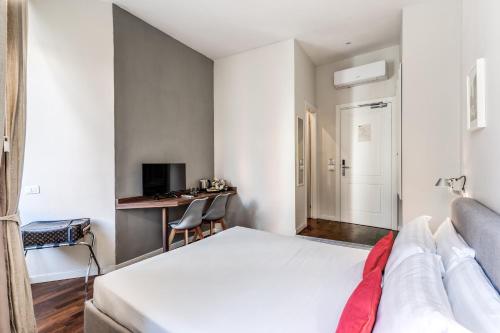 a bedroom with a white bed and a desk at Little Queen Relais in Rome