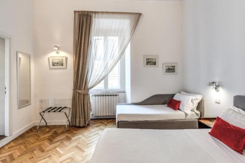 a bedroom with a bed and a couch and a window at Little Queen Relais in Rome