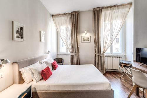 sypialnia z łóżkiem z czerwonymi poduszkami w obiekcie Little Queen Relais w Rzymie
