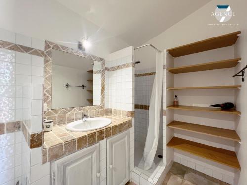 une salle de bain avec un lavabo et un miroir dans l'établissement Mazet Cocagne, à Sainte-Maxime