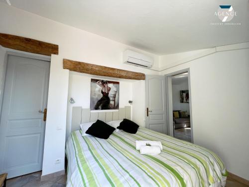 - une chambre avec un lit aux rayures vertes et blanches dans l'établissement Mazet Cocagne, à Sainte-Maxime