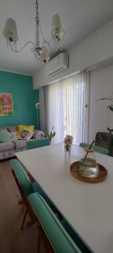 sala de estar con mesa blanca y paredes verdes en Departamento luminoso frente a plaza con balcón en La Plata