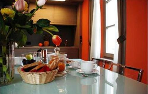 a table with a bowl of bread and a basket of fruit at Residence Hotel Serenella in Aprica