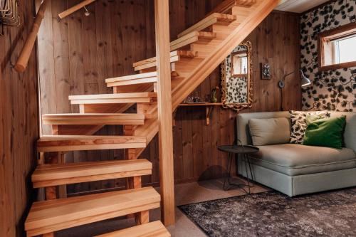 a wooden staircase in a room with a couch and a chair at Hotell Park in Västervik