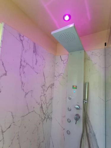a bathroom with a shower with a purple ceiling at Volaterrae Deluxe Loft with garden in Volterra