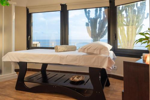 a bed in a room with a large window at Hotel Parigi & Spa in Bordighera