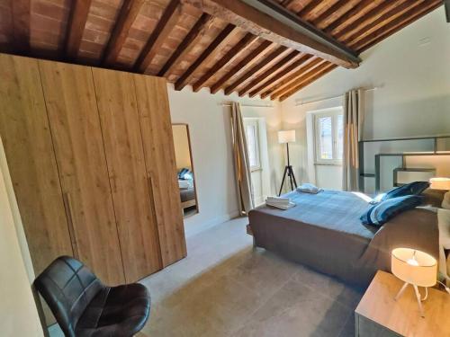 a bedroom with a bed and a wooden wall at Volaterrae Deluxe Loft with garden in Volterra