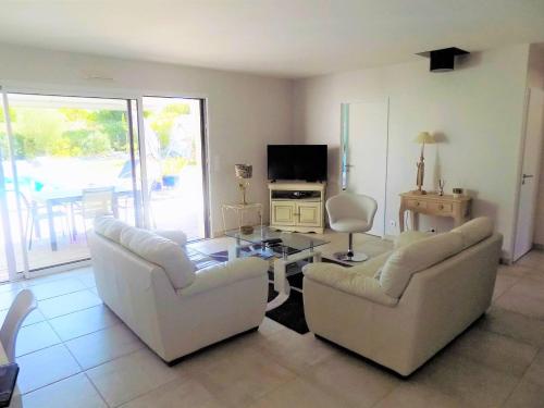 un salon avec deux canapés et une table dans l'établissement Meschers - MAISON RECENTE avec PISCINE PRIVATIVE dans un quartier très calme, à Meschers-sur-Gironde