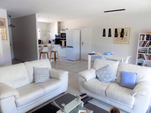 un salon avec deux canapés blancs et une cuisine dans l'établissement Meschers - MAISON RECENTE avec PISCINE PRIVATIVE dans un quartier très calme, à Meschers-sur-Gironde