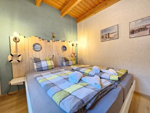 two twin beds in a room with wooden ceilings at Ferienhaus Nordseekrabbe in Norden