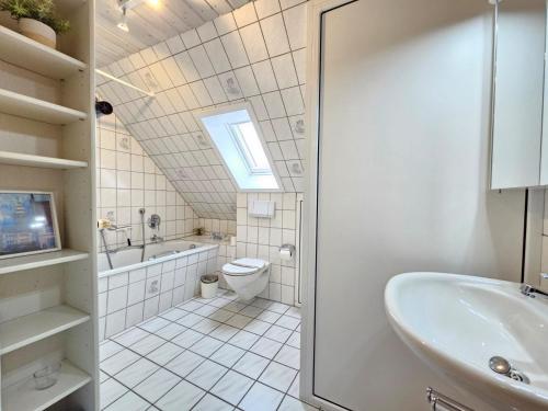 a bathroom with a sink toilet and a window at Ferienhaus Nordseekrabbe in Norden