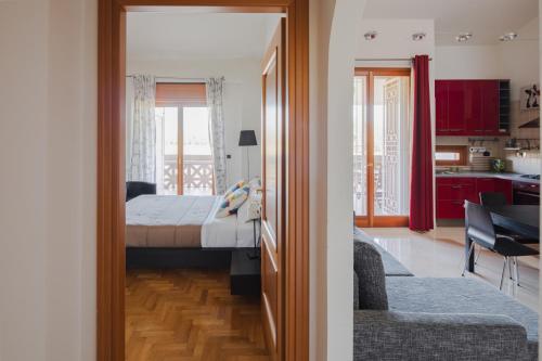 a bedroom with a bed and a living room with a kitchen at EUR Moravia Attico panoramico con terrazzo, fino a 5 ospiti in Rome