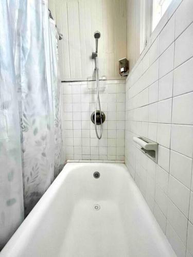 a white bath tub in a white tiled bathroom at New! Antique House at Ponce in Ponce