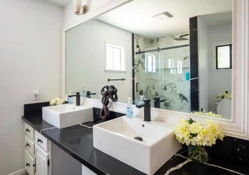 baño con 2 lavabos y espejo grande en Luxurious 9 Bedroom Home In Las Vegas en Las Vegas