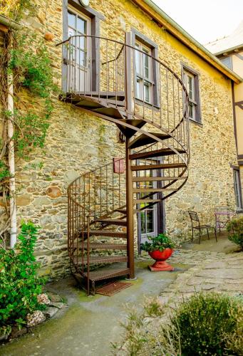 una scala a chiocciola in legno accanto a un edificio di Appart' d'hôtes , ch et gîte au Manoir de la Haute Pilais a Chantepie
