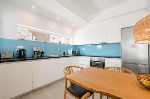 a kitchen with white cabinets and a wooden table at Villa Marina Hills in Makry Gialos