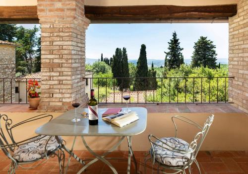 - une table avec deux verres de vin sur le balcon dans l'établissement Castello di Fonterutoli Wine Resort, à Castellina in Chianti