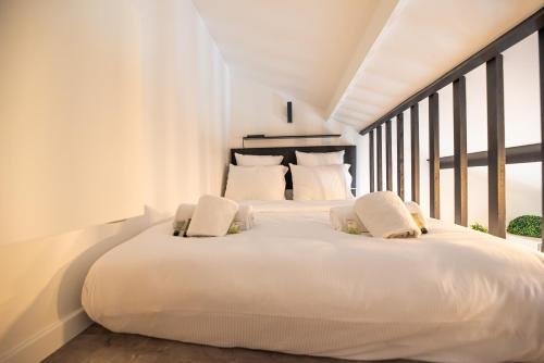 une chambre blanche avec deux lits et une fenêtre dans l'établissement Lovely Nest in Paris, à Paris