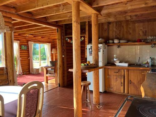 una cocina con armarios de madera y una mesa en una cabaña en Casa de Campo, en Villarrica