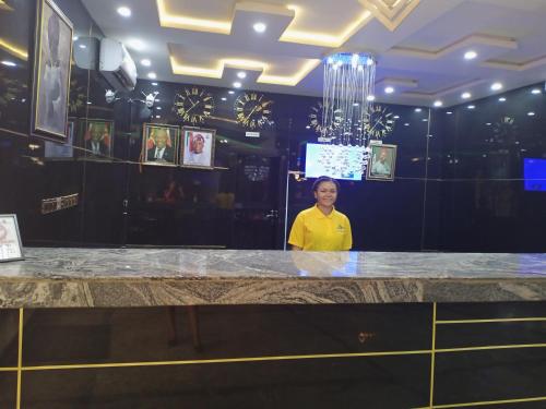 a woman standing behind a counter in a room at Givenchy Luxury Hotels and Suites in Akwa