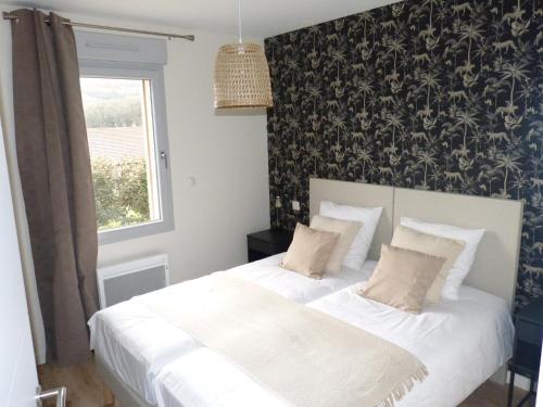 - une chambre avec un lit blanc et du papier peint noir et blanc dans l'établissement Le Coulabio Côté Soleil, Maison Lapopie 2, luxe et raffinement, à Tour-de-Faure