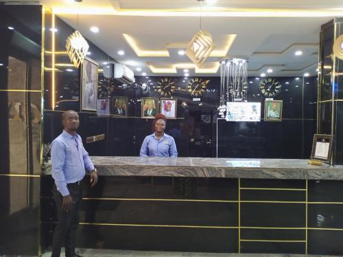 un hombre y una mujer de pie en un bar en Givenchy Luxury Hotels and Suites, en Akwa