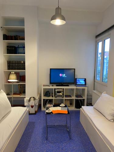 a living room with a couch and a tv at Sacred Way Modern apartment in Athens