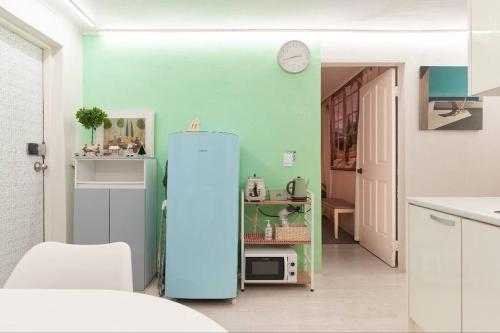 W pokoju znajduje się kuchnia z niebieską lodówką. w obiekcie Mapo Hongdae Detached Home w Seulu