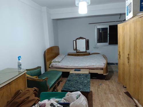 a hospital room with a bed and a table and chairs at The sea apartment in ‘Izbat al Qaşr