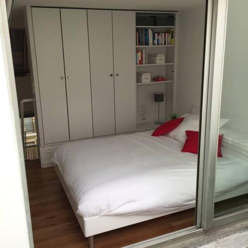 - une chambre avec un grand lit blanc et des armoires blanches dans l'établissement Duplex près des Champs-Élysées, à Paris