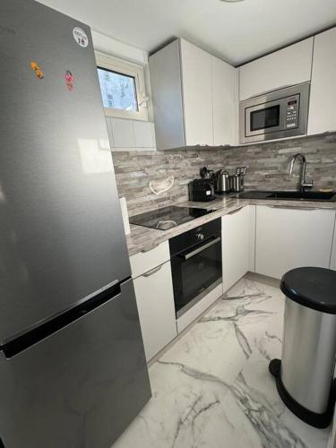 Il comprend une cuisine équipée d'un réfrigérateur et d'appareils en acier inoxydable. dans l'établissement Duplex près des Champs-Élysées, à Paris