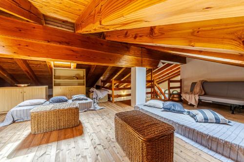 three beds in a room with wooden ceilings at Casa Beatrice in Courmayeur