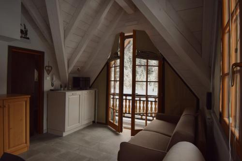 sala de estar con sofá y ventana en MONOLOCALE STELLALPINA - PONTE DI LEGNO-, en Ponte di Legno