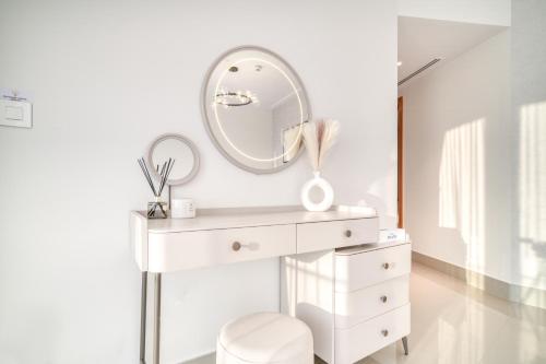 a white dressing table with a mirror and a stool at Downtown Luxury - Stunning Burj Khalifa & Sea View - 5 Minutes Walk to Dubai Mall in Dubai