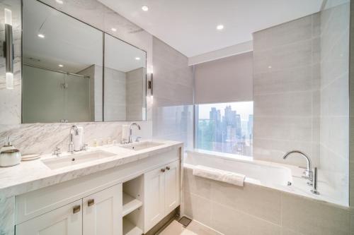 a bathroom with two sinks and a large mirror at Downtown Luxury - Stunning Burj Khalifa & Sea View - 5 Minutes Walk to Dubai Mall in Dubai