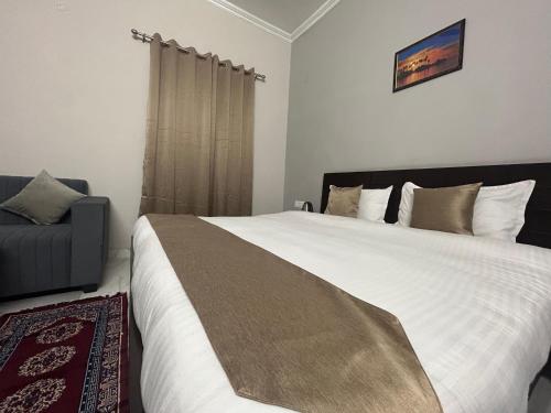 um quarto com uma grande cama branca e uma cadeira em RAJ RESIDENCY em Gurgaon