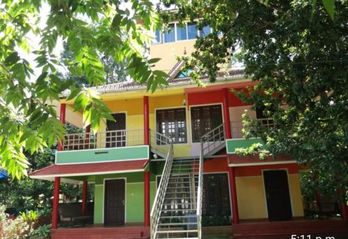 a colorful building with a staircase in front of it at Rainbow holiday home in Kalpetta