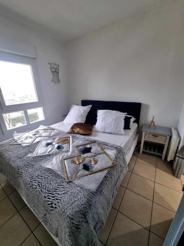 - une chambre avec un lit à tête bleue dans l'établissement Appartement Village Naturiste Electra, au Cap d'Agde